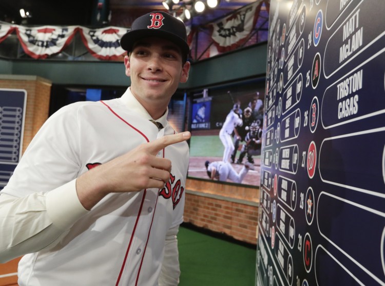 Triston Casas, 18, poses at the overall draft board Monday night after being selected in the first round of the major league draft by the Boston Red Sox with the 26th pick.