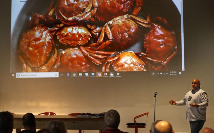 Jamie Bassett, a crabber from Chatham, Mass., presents culinary uses for green crabs at a conference in Portland on Wednesday. The crabs will be harvested if there's a market, potentially reducing their predation of shellfish.