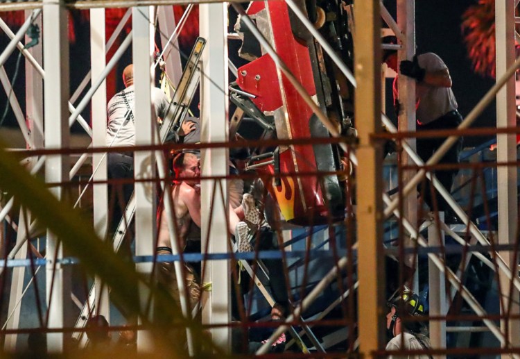 Daytona Beach Fire Department personnel rescue riders from a roller coaster car that derailed.