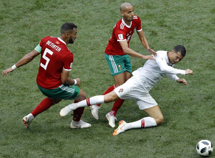 Morocco's Mehdi Benatia, left, and Morocco's Karim El Ahmadi, center, challenge for the ball with Portugal's Cristiano Ronaldo, right, during the group B match between Portugal and Morocco at the 2018 soccer World Cup in Moscow on Wednesday. (AP Photo/Victor Caivano)
