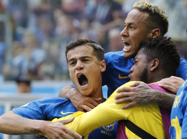 Brazil's Philippe Coutinho, left, celebrates scoring in the first minute of stoppage time with Neymar, top, and teammates during Friday's 2-0 win over Costa Rica in St. Petersburg, Russia.