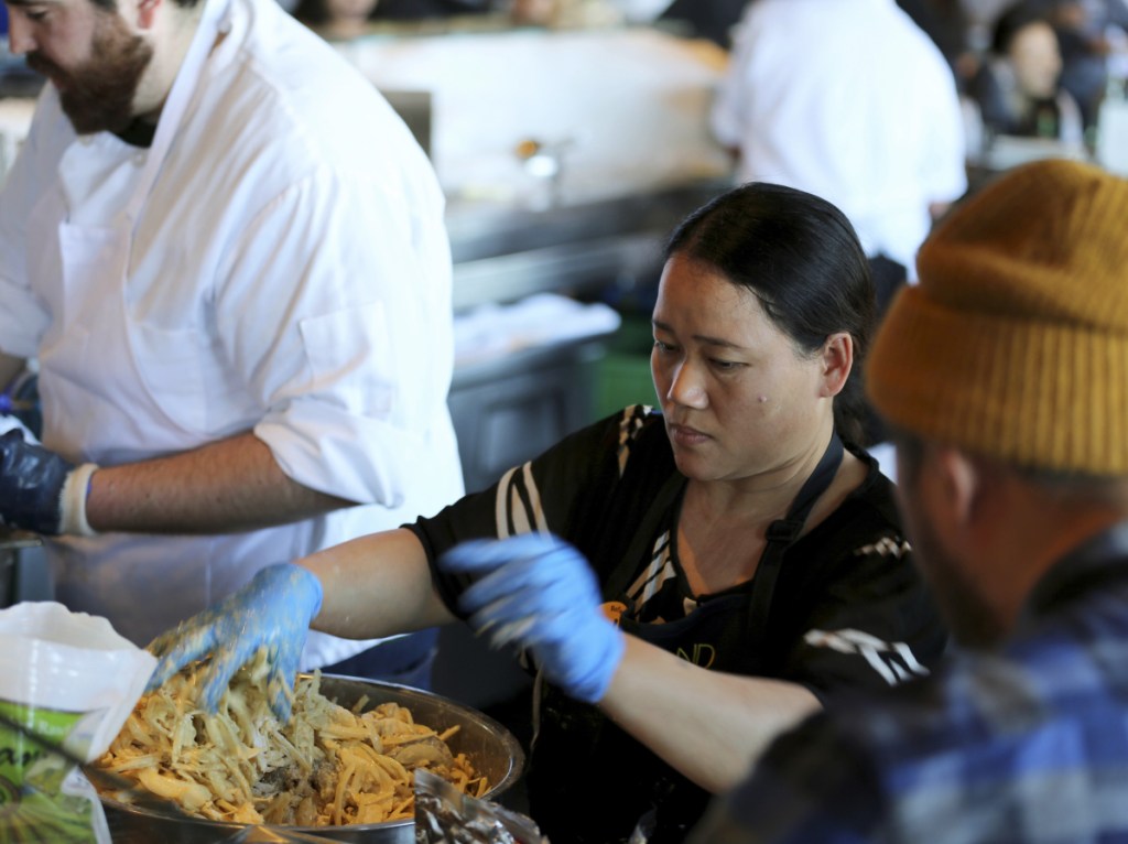 Pa Wah, a refugee from Myanmar, mixes shrimp in a turmeric tempura batter at the Hog Island Oyster Co. restaurant during the Refugee Food Festival.