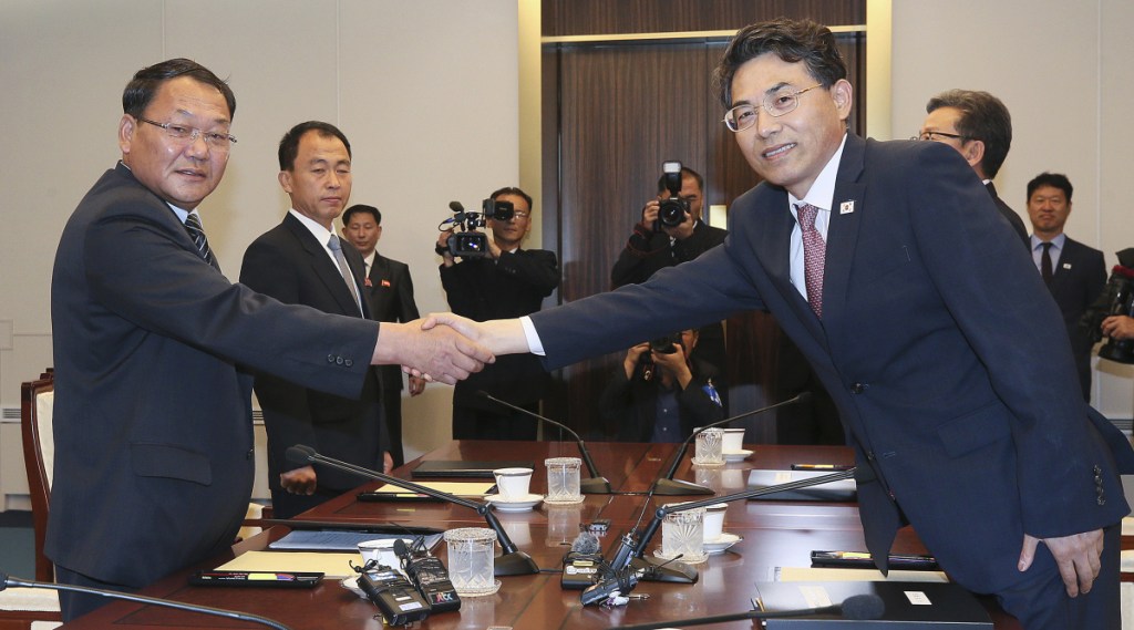 North Korean Vice Railroad Minister Kim Yun Hyok, left, shakes hands with his South Korean counterpart Vice Transport Minister Kim Jeong-ryeol during a meeting to discuss inter-Korean cooperation on railway upgrades. The meeting was held inside the Peace House at the border village of Panmunjom, South Korea, on Tuesday. (Korea Pool via AP)
