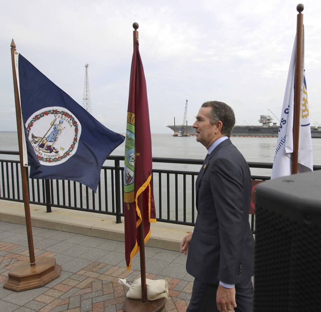 Gov. Ralph Northam walks to the podium Tuesday at a park in Newport News, Va., to discuss the state's support for Newport News Shipbuilding's hiring initiative. He said the state will help recruit and train workers.