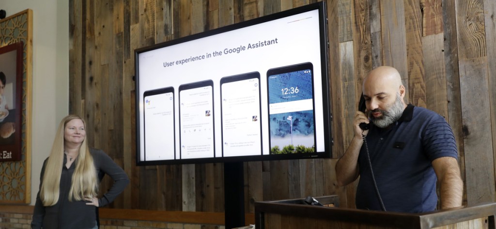 Oren Dobronsky, right, owner of Oren's Hummus in Mountain View, Calif., demonstrates the Duplex program that will book an appointment over the phone, alongside Valerie Nygaard, product manager for Google. "I think it will just bring more business," Dobronsky said.