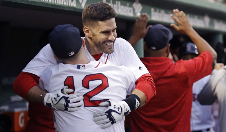 Boston Red Sox's J.D. Martinez is embraced by Brock Holt after belting a three-run home run off Los Angeles Angels starting pitcher Andrew Heaney in the second inning Wednesday night at Fenway Park.