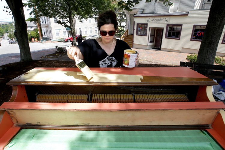 Adria Moynihan Rusk, founder of Still Life Studio, paints an upright piano on Wednesday in Bramhall Park, where it will eventually be displayed.