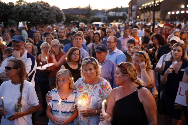 Mourners stand in silence during a vigil in response to a shooting at the Capital Gazette newsroom, Friday in Annapolis, Md. Prosecutors say 38-year-old Jarrod W. Ramos opened fire Thursday in the newsroom.