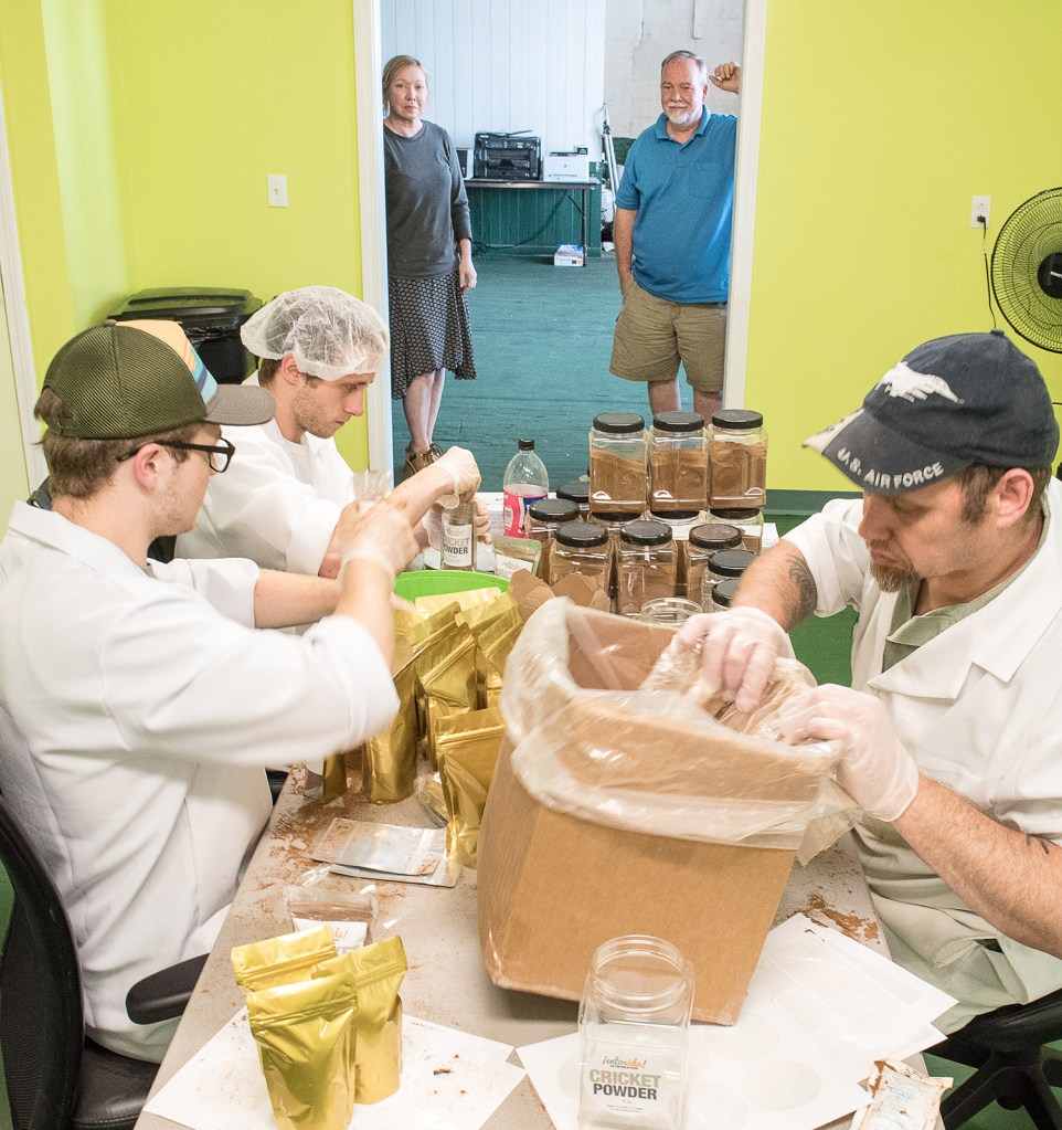 Sister and brother Susan and Bill Broadbent, background, watch employees package cricket powder at their business, Entosense LLC, at the Hill Mill in Lewiston on Tuesday.