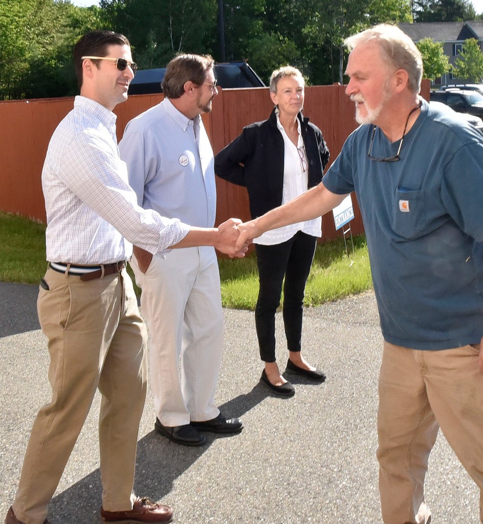 Waterville resident Brad Sherwood, right, shakes hands with Waterville Mayor Nick Isgro during early voting at Thomas College on Tuesday. Isgro is the subject of a recall effort spearheaded by former mayor Karen Heck at right. Candidate Mark Andre' is in center. Upon meeting Isgro in line, Heck said to him, " Good luck today Nick, you're going to need it." 