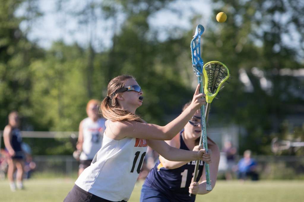 Winslow senior captain Cassie McCaslin goes for the ball as Boothbay's Kylie Brown defends during the regular season finale May 29 at Kennebec Savings Bank Field in Winslow.