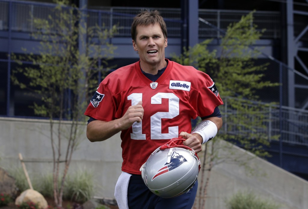 New England Patriots quarterback Tom Brady steps onto the field at the start of minicamp practice Tuesday in Foxborough, Massachusetts.
