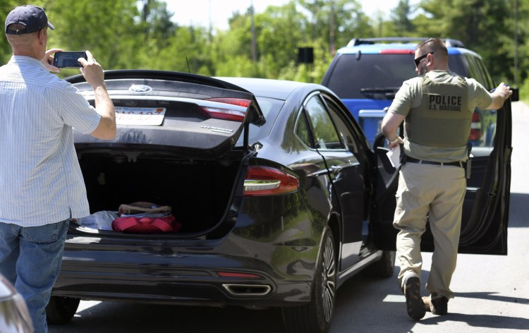 Federal and state investigators process a vehicle May 30 after agents stopped it and arrested the driver, Yashonia Michele Davis, who allegedly was involved in a homicide in New York.