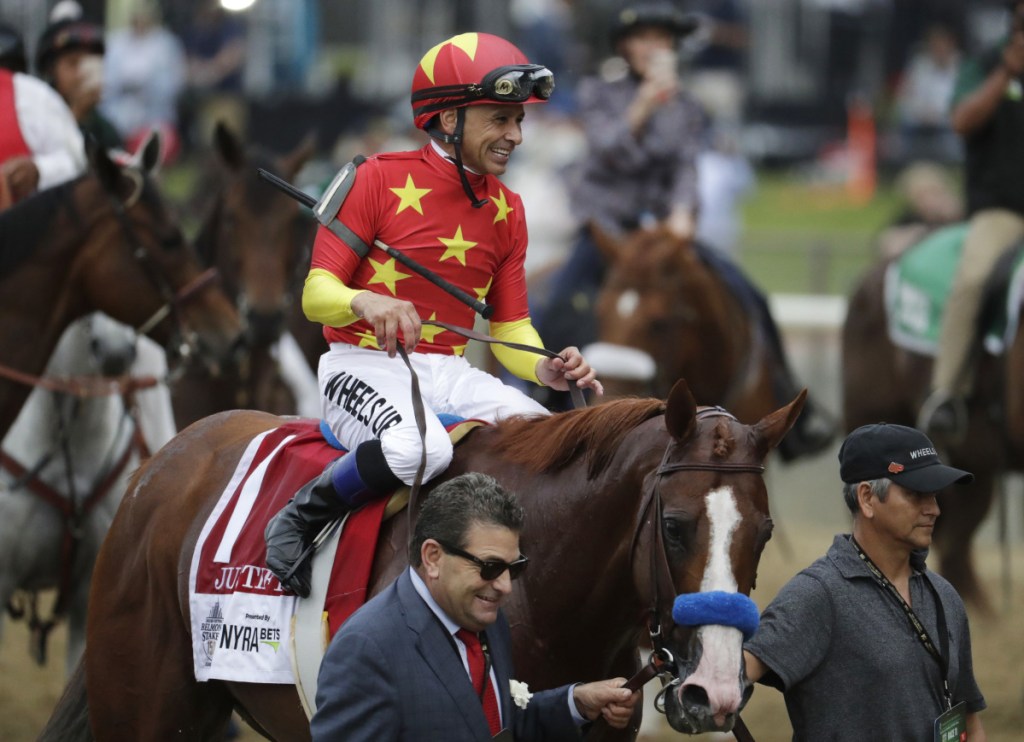 Jockey Mike Smith rides Justify to the winner's circle after winning the 150th running of the Belmont Stakes Saturday in Elmont, New York.