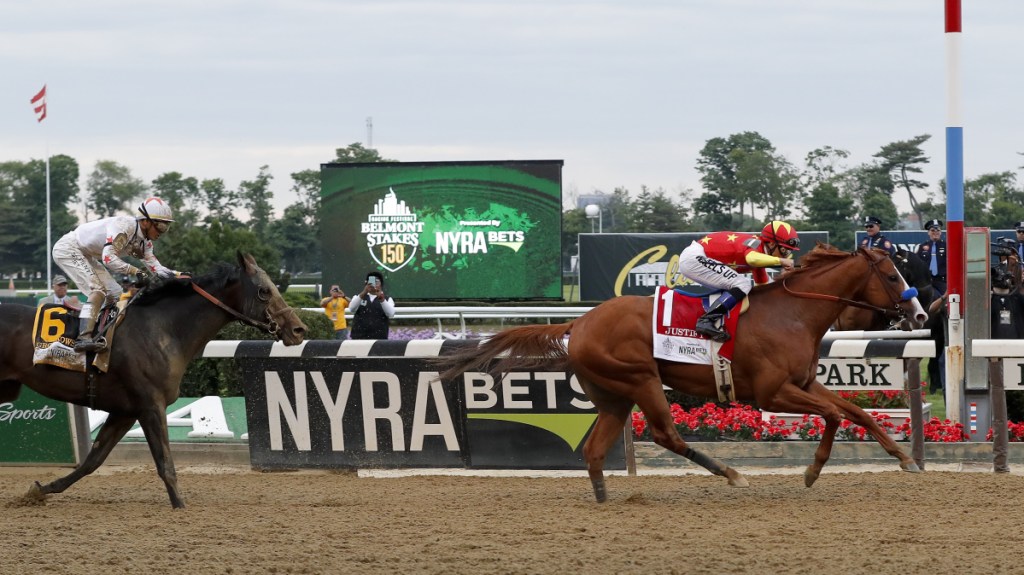 Justify crosses the finish line ahead of Gronkowski to win the 150th running of the Belmont Stakes and the Triple Crown on Saturday in Elmont, New York.