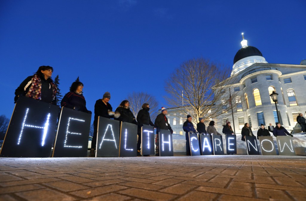 Mainers for Health Care rally outside the State House prior to Gov. Paul LePage's State of the State address, Tuesday, Feb. 13, 2018, in Augusta, Maine. The coalition that supported the successful Yes on 2 campaign to expand Medicaid in 2017 say LePage and his allies in the Legislature are trying to block Medicaid expansion, which is now state law. (AP Photo/Robert F. Bukaty)