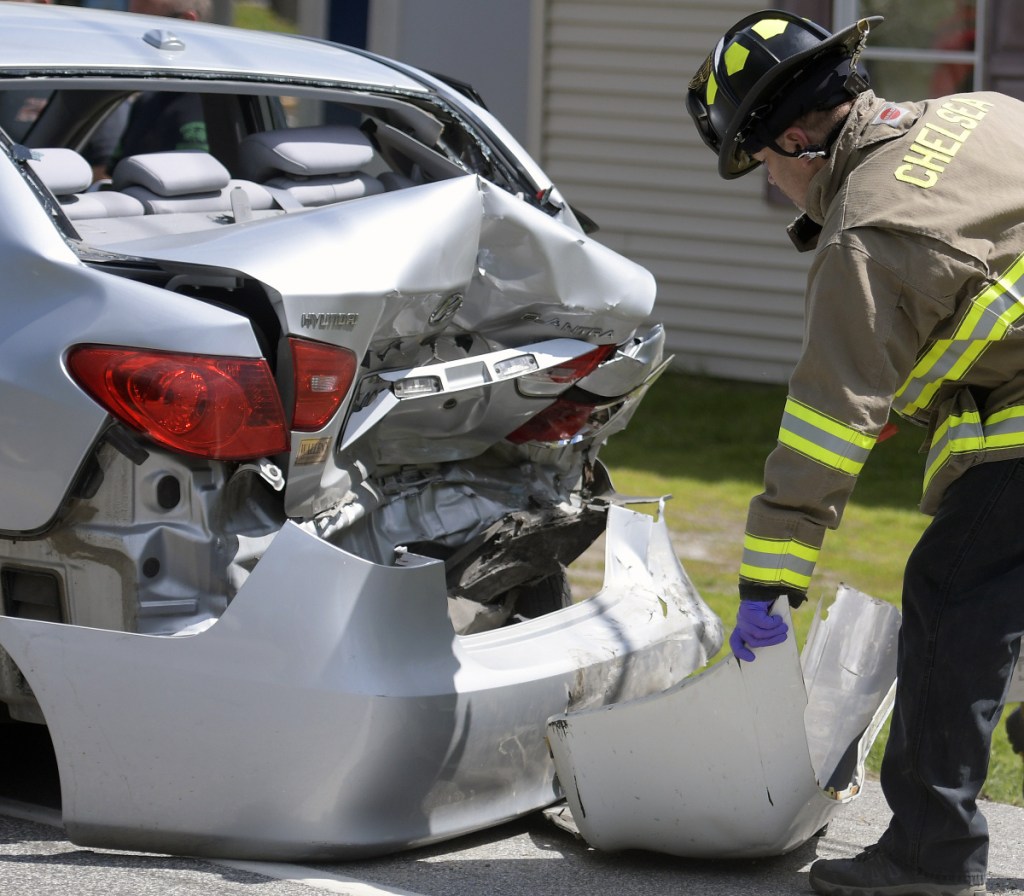 Firefighters collect debris from a two-car crash on Route 17 in Chelsea on Monday.