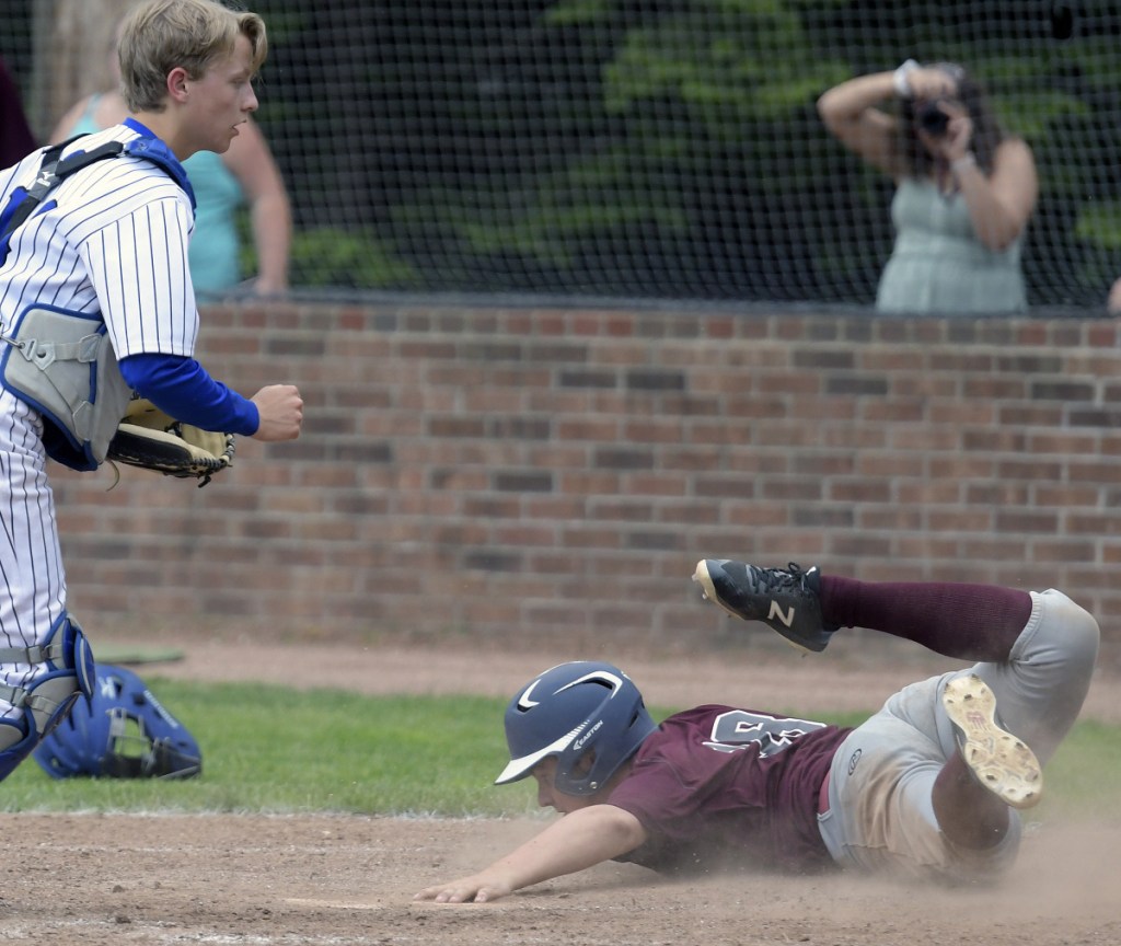 Richmond's Kyle Tilton slides into home in front of Searsport's Charlie Spiegel during a Class D South regional final game Wednesday in Standish.