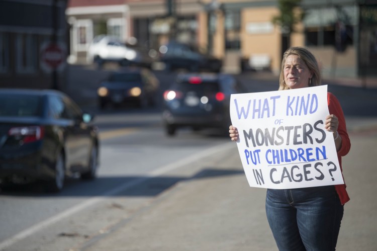 Hope Savage holds a sign Wednesday on the Margaret Chase Smith Bridges in Skowhegan in protest of the detention and separation of immigrant families along the Mexican border.