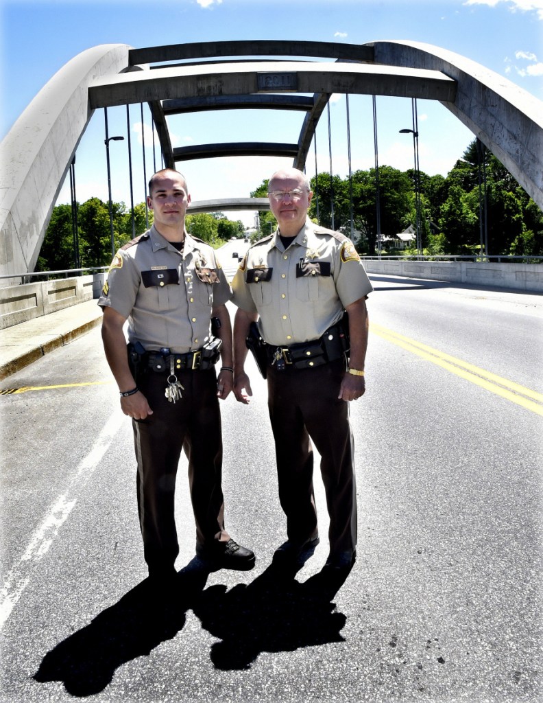 Somerset Deputy David Cole, left, son of Cpl. Eugene Cole, who was killed in the line of duty, and Somerset Sheriff Dale Lancaster on Thursday stand on the bridge spanning the Kennebec River in Norridgewock that a bill in the Legislature calls for naming the Cpl. Eugene Cole Memorial Bridge.
