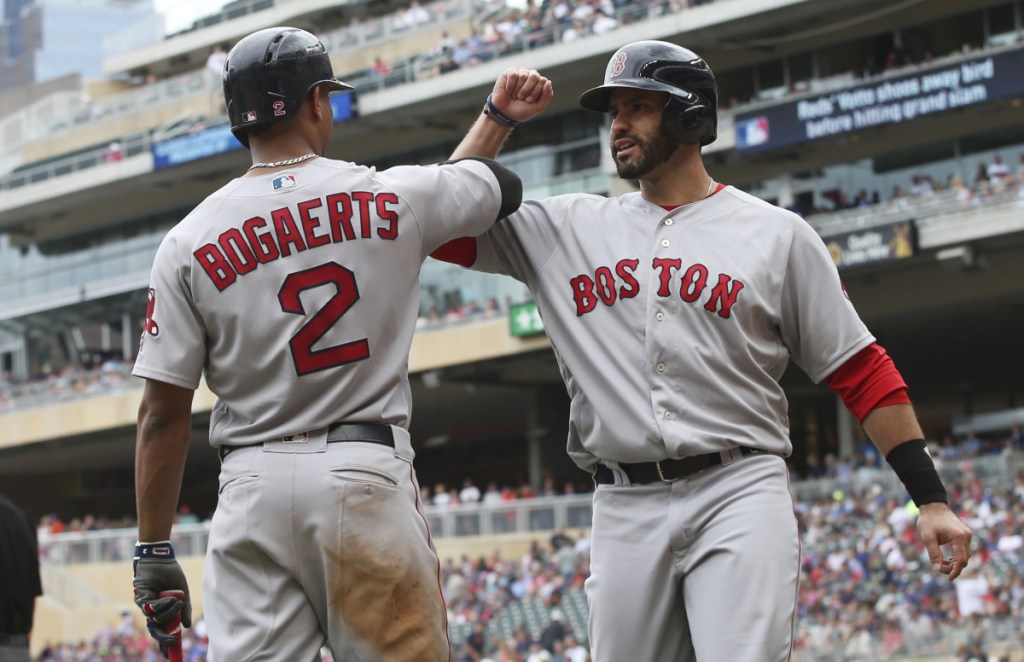 Boston's Xander Bogaerts, left, celebrates with J.D. Martinez after he scored on a double by Mitch Moreland in the eighth inning Thursday in Minneapolis. The Red Sox won 9-2.