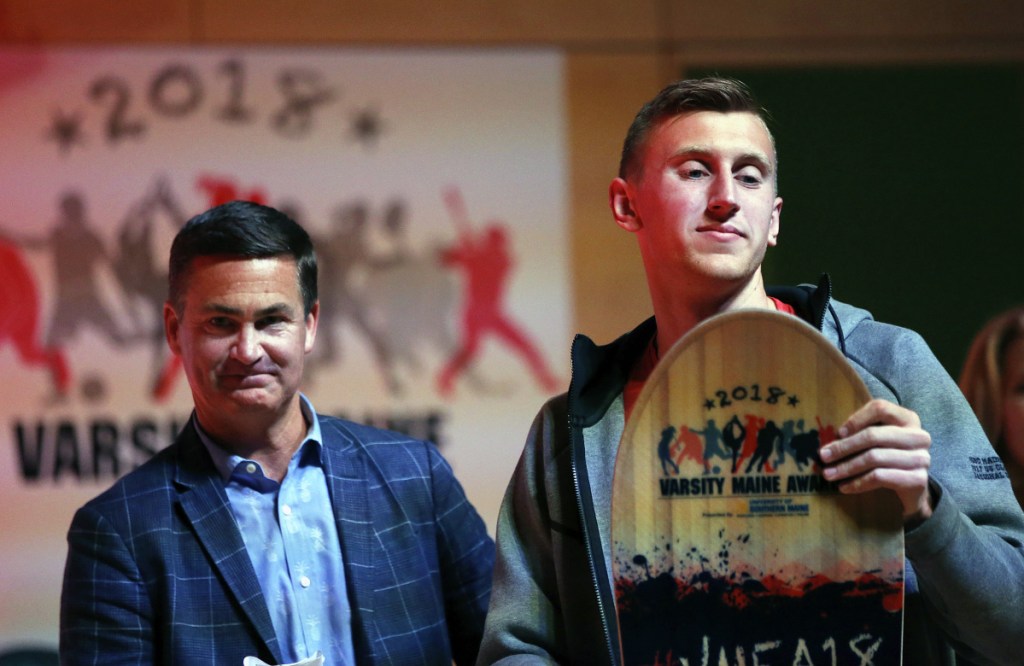 Cole Smith of Messalonskee High School, right, shares the stage with presenter Brian Corcoran, CEO of Shamrock Sports, after Smith won an Academic Ace award on Tuesday during the 2018 Varsity Maine Awards at Hannaford Hall on University of Southern Maine's Portland campus.