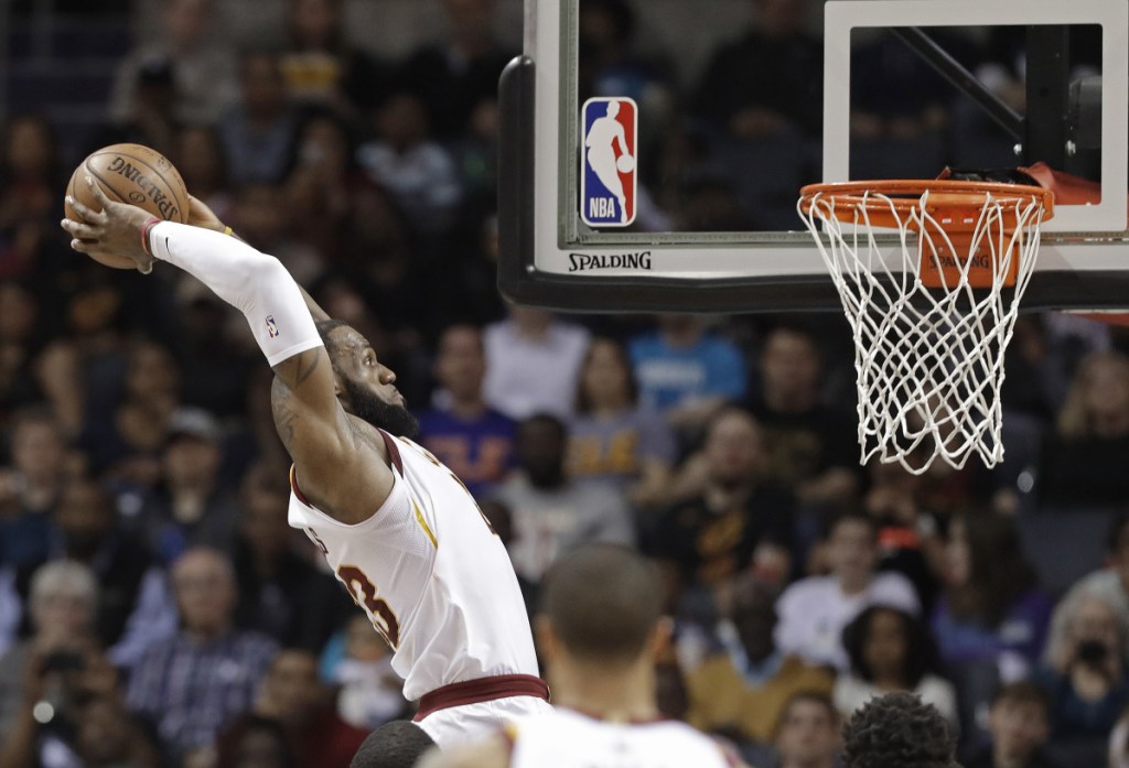 In this March 28 photo, Cleveland Cavaliers' LeBron James goes up to dunk against the Charlotte Hornets in Charlotte, North Carolina.