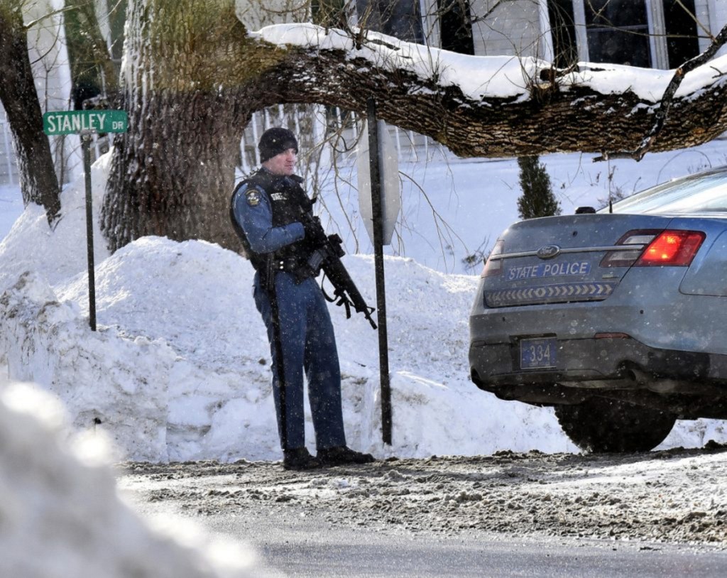 A Maine State Trooper with an assault rifle stands guard in January at one end of Stanley Drive in Norridgewock as police search for a suspect in an armed robbery at the nearby Skowhegan Savings Bank branch.