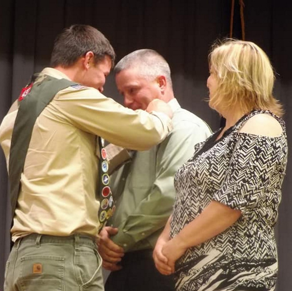Hunter Cuddy presents a pin to his father Ed Cuddy for all of his support during Hunter's Scouting career, as his mom Michele Cuddy looks on.