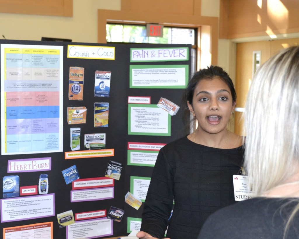 Purvi Patel, a pharmacy student, encourages participants to play medication jeopardy during Franklin Memorial Hospital's business-after-hours health fair.