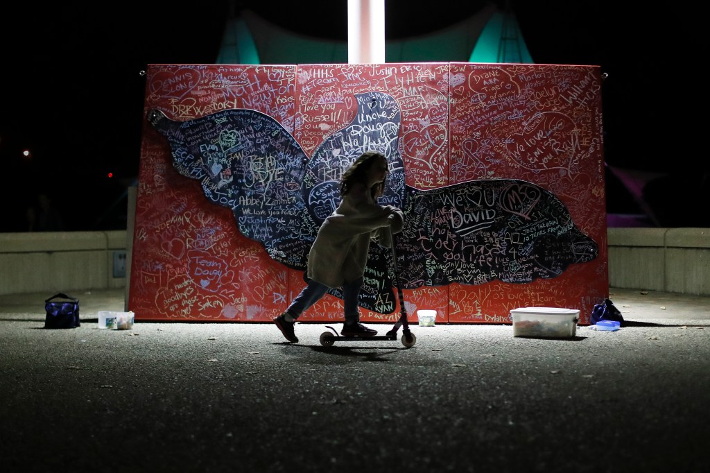 A child plays beside a message board adorned with notes for loved ones who took their own lives during an Out of the Darkness Walk event 
on Oct. 15, 2017, organized by the Cincinnati Chapter of the American Foundation for Suicide Prevention at Sawyer Point Park in Cincinnati. Suicide rates inched up in nearly every U.S. state from 1999 through 2016, according to a new government report released Thursday. 