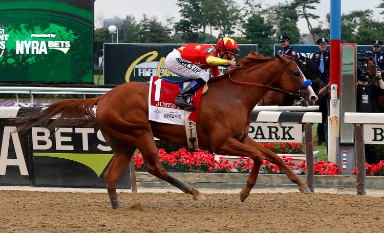 Justify (1), with jockey Mike Smith up, crosses the finish line to win the 150th running of the Belmont Stakes on Saturday in Elmont, N.Y. Justify became the 13th horse to win the Triple Crown.