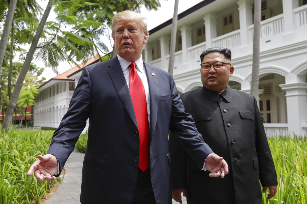 President Trump and North Korea leader Kim Jong Un stop to talk with the media as they walk from their lunch at the Capella resort on Sentosa Island, Singapore.