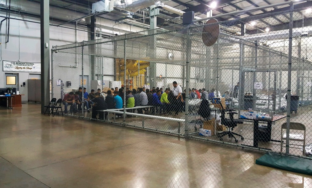 In this photo provided by U.S. Customs and Border Protection, people who've been taken into custody related to cases of illegal entry into the United States, sit in one of the cages at a facility in McAllen, Texas, Sunday, June 17, 2018. 