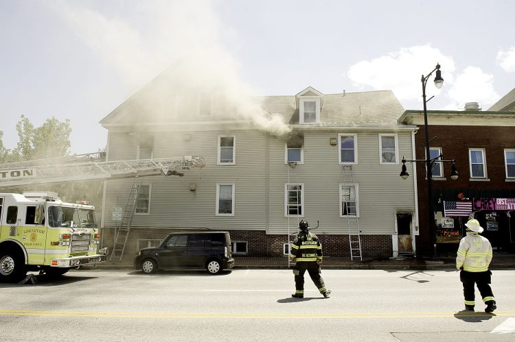 Auburn and Lewiston firefighters battle a fire at 67 Pleasant St. in Auburn on Friday. The fire displaced 14 people.