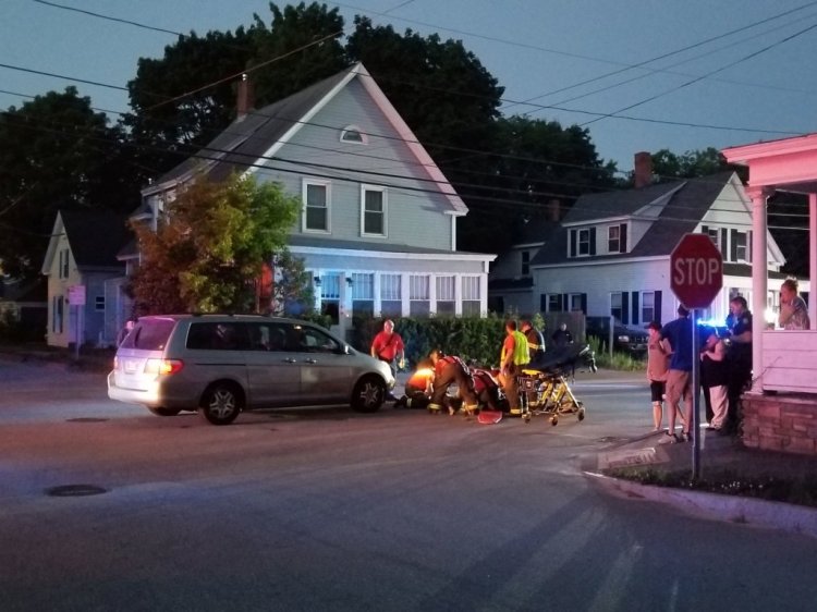 Emergency responders tend to the victim of a van-ATV crash Friday night on Summer Street in Auburn. 