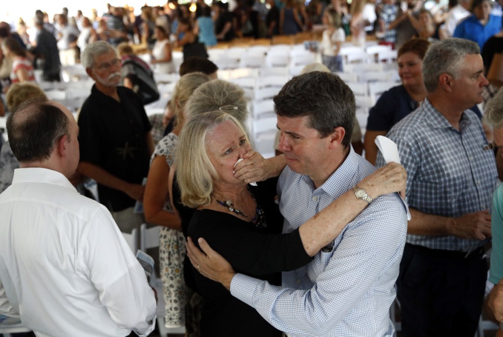 Judy Hiaasen, center left, sister of Rob Hiaasen, one of the journalists killed in the shooting at The Capital Gazette newspaper offices, hugs her nephew Scott following a memorial service Monday in Owings Mills, Md. ()
