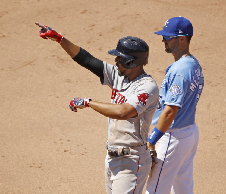 Boston's Xander Bogaerts, left, celebrates at second base as Kansas City's Whit Merrifield looks on after Bogaerts hit an RBI double in the seventh inning of the Red Sox' 7-4 win Sunday in Kansas City, Mo.