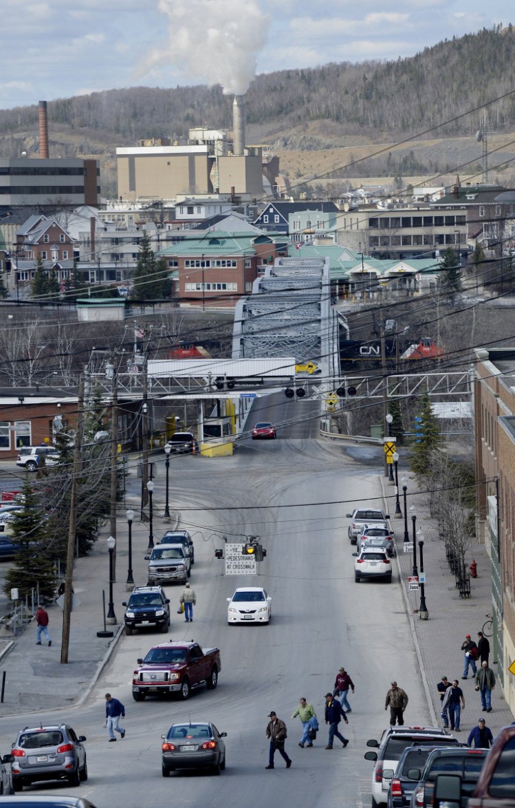 MADAWASKA, ME - MAY 8: Paper Mill workers file out onto Bridge Ave. after their shift Thursday, May 8, 2014.  Edmundston, Canada can be seen across the bridge.(Photo by Shawn Patrick Ouellette/Staff Photographer)