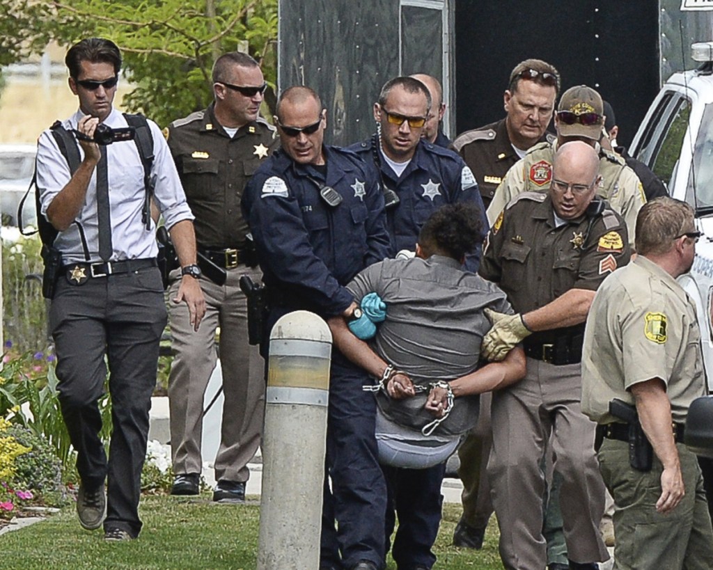 Activists are removed from a building in Centerville, Ore., on Thursday after they protested a private prison company that has contracts with the government to hold immigrants. escorted out of a building where they staged a protest against a private prison company with contracts to hold immigrants on Thursday, July 12, 2018, at the headquarters of Management and Training Corporation in Centerville, Ore.