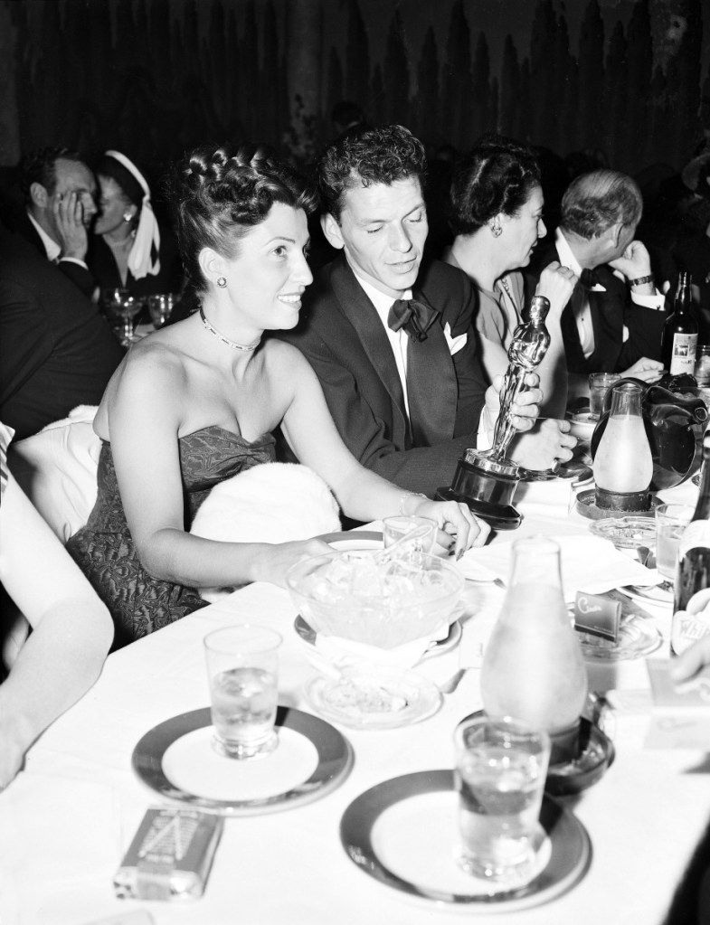 At a crowded table at Ciro's in March of 1946, Frank Sinatra steals a glance at the Oscar he won for his performance in the film "The House I Live In," as his wife Nancy looks on. Nancy Sinatra Sr., the childhood sweetheart of Frank Sinatra who became the first of his four wives and the mother of his three children, has died. She was 101. Her daughter, Nancy Sinatra Jr., tweeted that her mother died Friday, July 13, 2018.  ()