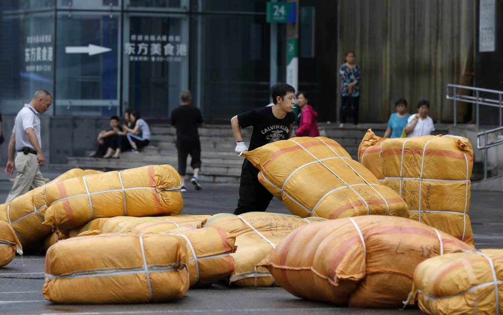 A worker loads goods outside a retail and wholesale clothing mall in Beijing. China's filing of a complaint with the WTO may help rally support from governments critical of U.S. actions to impose tariffs on Chinese and other imports.