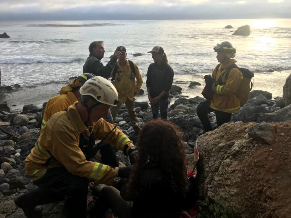 Authorities tend to Angela Hernandez, foreground center, as she is rescued from an isolated beach in Morro Bay, Calif. "For her to survive for seven days ... with injuries that she had is amazing," the sheriff said.