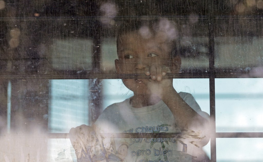 An immigrant child looks out from a U.S. Border Patrol bus leaving as protesters block the street outside the U.S. Border Patrol Central Processing Center in McAllen, Texas, last month. Immigrant children described hunger, cold and fear in a voluminous court filing about the facilities where they were held in the days after crossing the border.