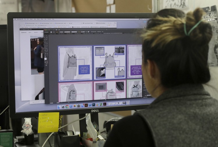Designer Tiffany Tam examines sketches of a handbag she designed on her computer at Betabrand in San Francisco.