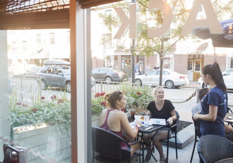 Ellie Napoli, left, and Darian Blevins talk with their server on the inviting patio at Maine Lobster Shack. The restaurant opened in April on Fore Street in Portland's Old Port.