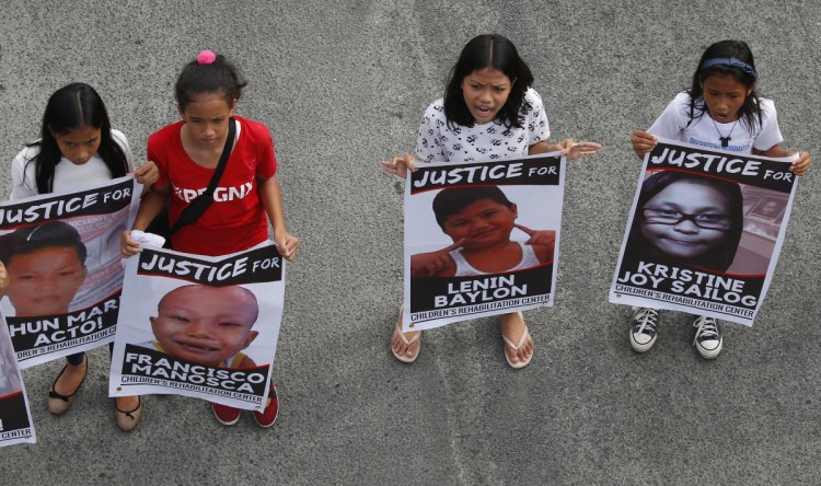 Protesters hold posters of young victims who died under President Rodrigo Duterte's so-called war on drugs during a rally coinciding with his third State of the Nation Address Monday, July 23, 2018, in Quezon city, northeast of Manila, Philippines. The protesters assailed Duterte for allegedly failing in his promises to alleviate poverty as well as his so-called war on drugs which saw the killings of thousands, mostly the poor. (AP Photo/Bullit Marquez)