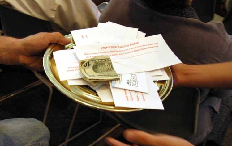 A collection plate containing envelopes specifically for the victims of Hurricane Katrina is passed during church service, at the Jersey Baptist Church in Pataskala, Ohio, in 2005.
