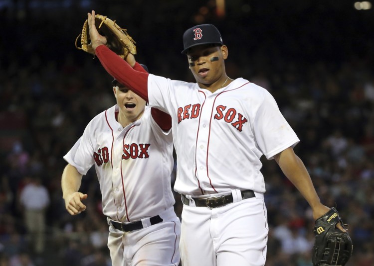 Boston Red Sox third baseman Rafael Devers, right, was placed on the disabled list before Sunday's series finale with a strained left hamstring.