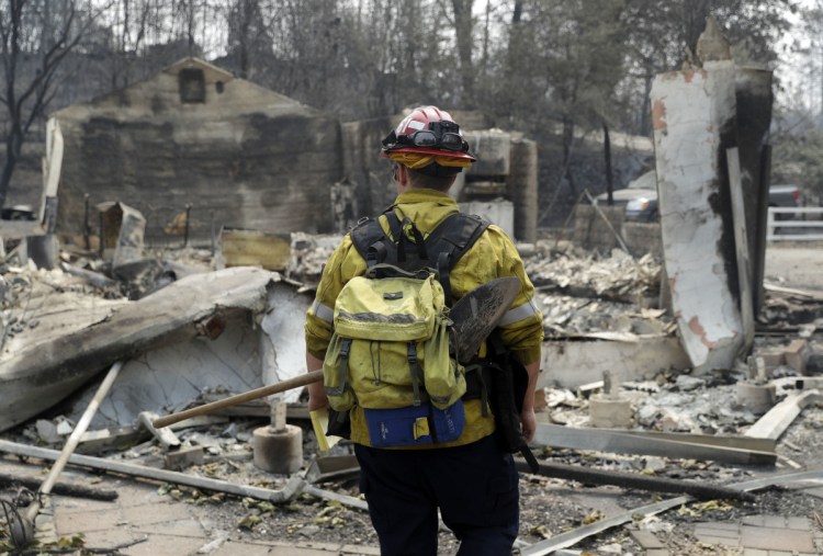 Capt. Scott Fisher, with the San Bernardino County Fire Department, surveys a wildfire-damaged neighborhood Sunday in Keswick, Calif.
